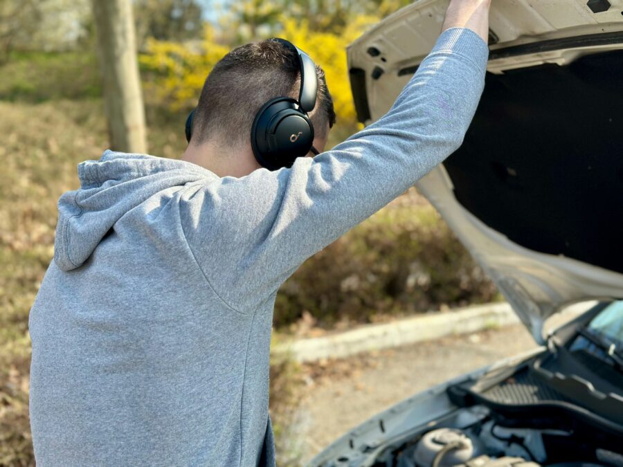 ヘットホン付けた人が車のボンネットを開けている